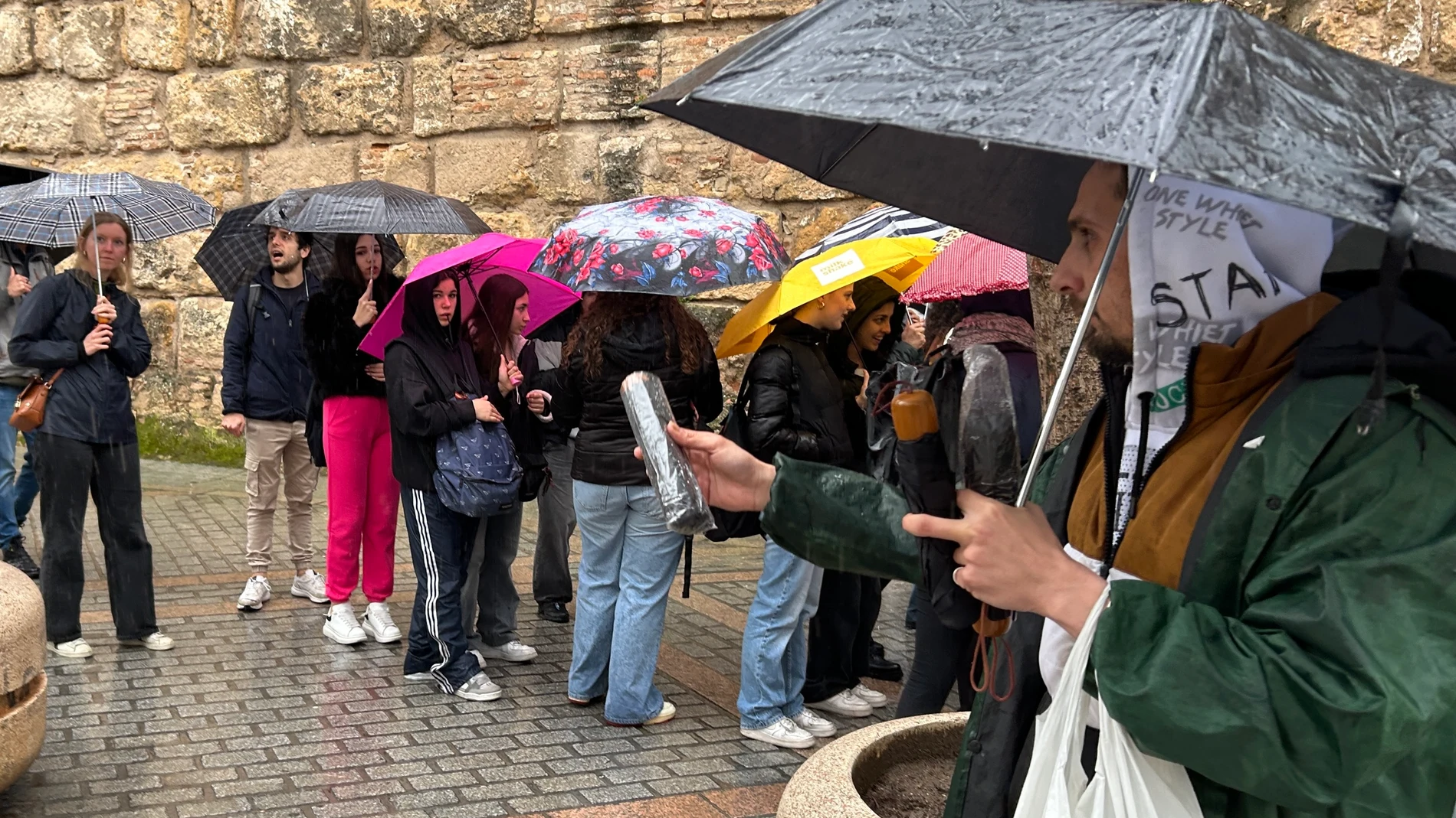 SEV09. SEVILLA, 10/03/2025.-Un hombre vende paraguas a los turistas en la puerta del Real Alcázar de Sevilla, este lunes en el que Andalucía repite cielos muy nubosos o cubiertos, con chubascos generalizados y ocasionalmente acompañados de tormentas, que podrán ser localmente fuertes, y persistentes en el sur de la comunidad, según la predicción de la Agencia Estatal de Meteorología (Aemet). EFE/Fermín Cabanillas