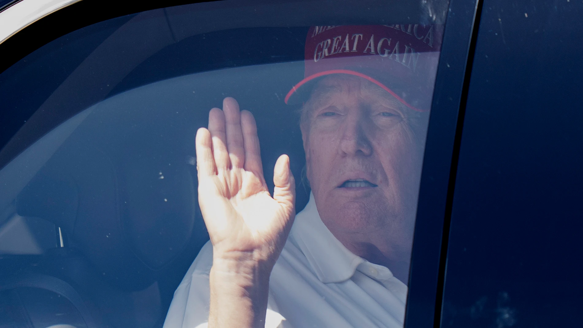 President Donald Trump waves from his limousine as he leaves Trump International Golf Club, Saturday, March 15, 2025, in West Palm Beach, Fla. (AP Photo/Manuel Balce Ceneta)