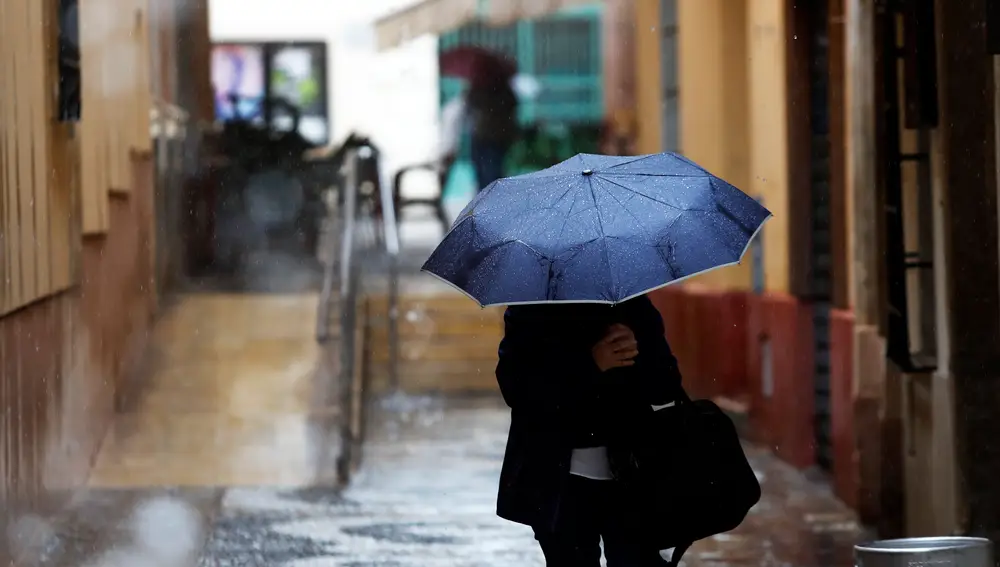 Una persona se protege de la lluvia en Málaga el pasado jueves