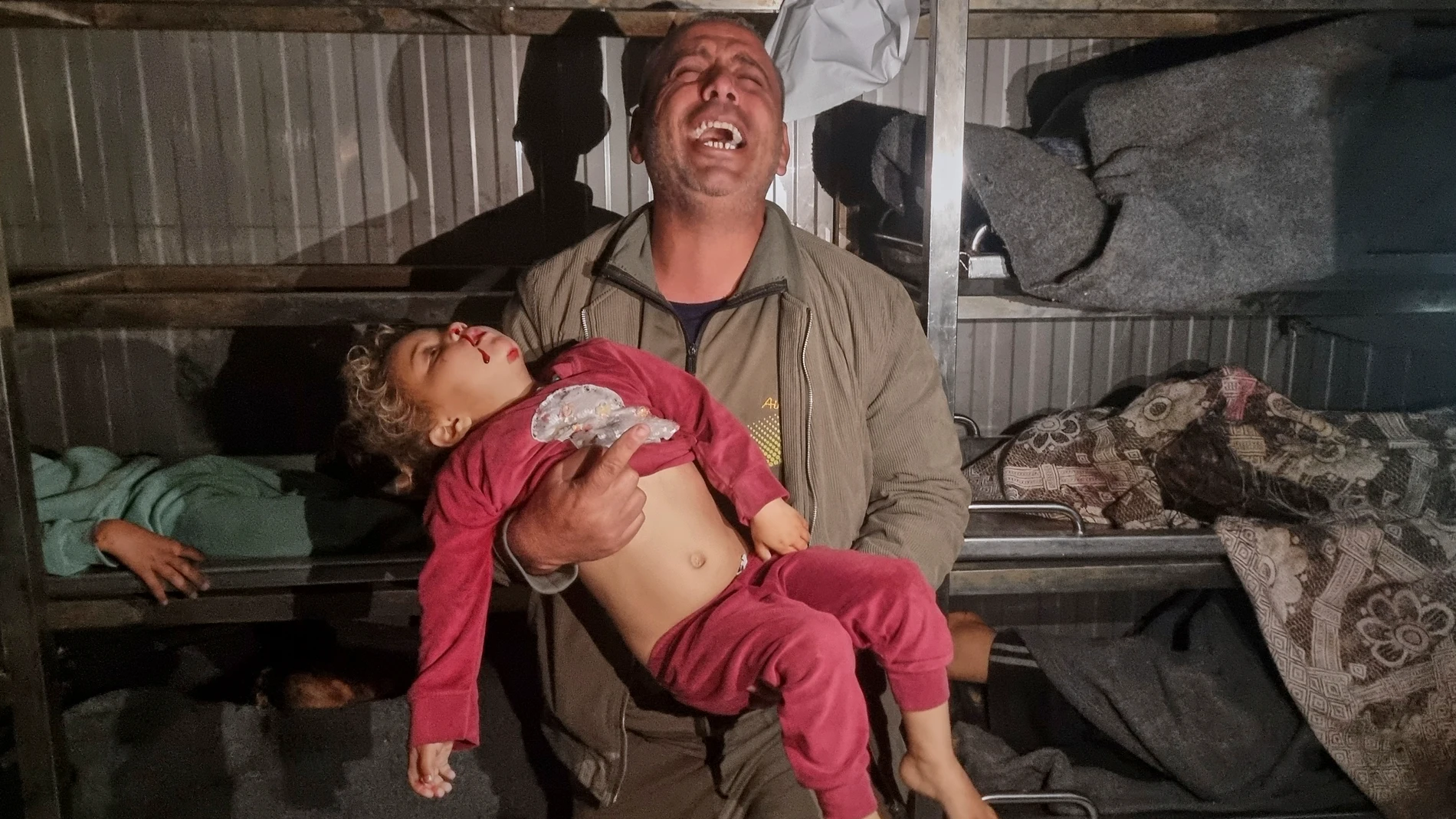 EDS NOTE GRAPHIC CONTENT.- A man holds the body of a dead child after Israeli airstrikes at the morgue of the hospital in Khan Younis, southern Gaza Strip, Tuesday March 18, 2025.(AP Photo/ Mohammad Jahjouh)