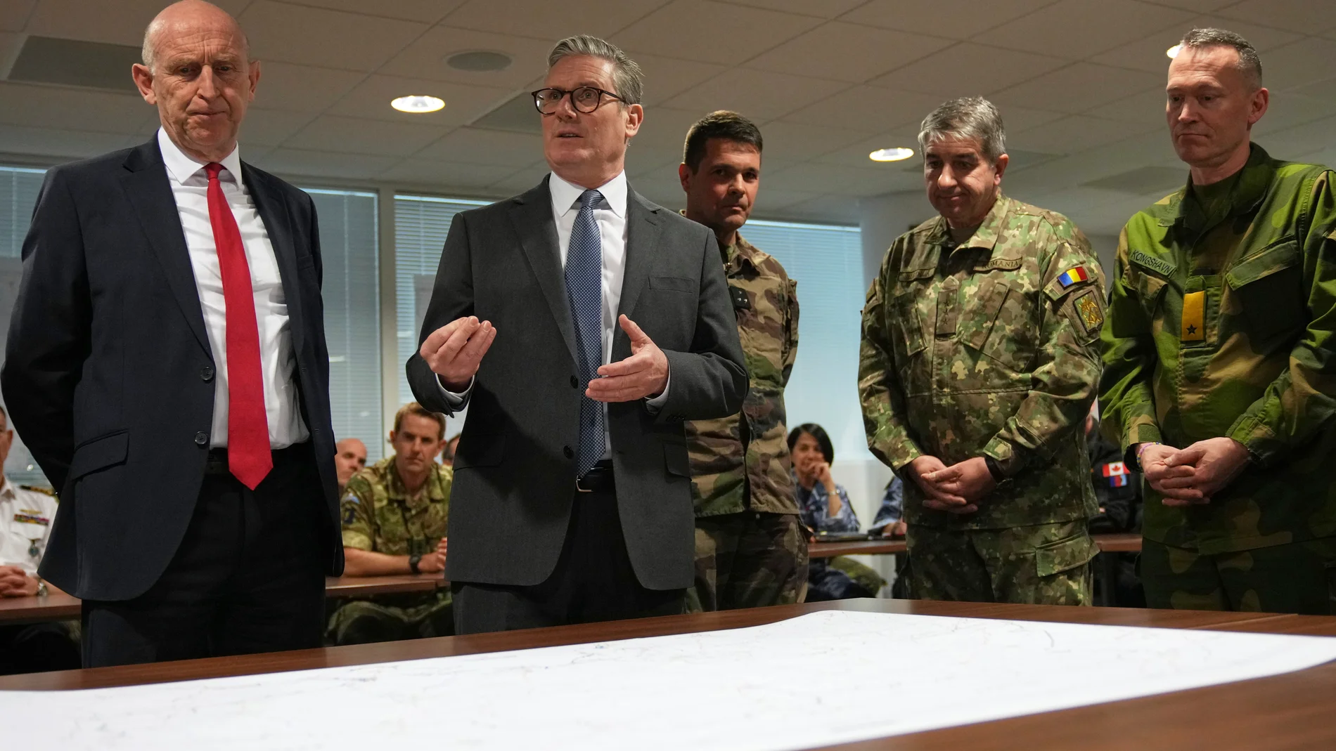 Britain's Prime Minister Keir Starmer and John Healey, Secretary of State for Defence, center left, look at a Ukraine map as they visit a military base to meet planners mapping out next steps in the Coalition of the Willing in Northwood, London, Thursday, March 20, 2025.(AP Photo/Alastair Grant, Pool)