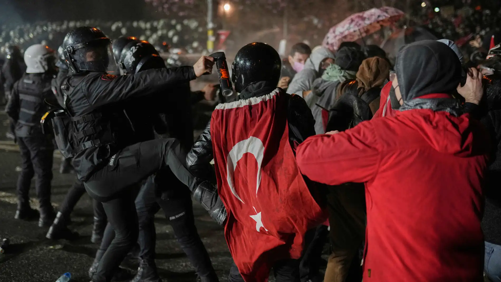 A riot police officer kicks a protester as they clash during a protest after Istanbul's Mayor Ekrem Imamoglu was arrested and sent to prison, in Istanbul, Turkey, Sunday, March 23, 2025. (AP Photo/Francisco Seco)