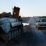 Un vehículo pasa junto a un carro de combate ruso destruido en la frontera entre Járkiv y Dónetsk