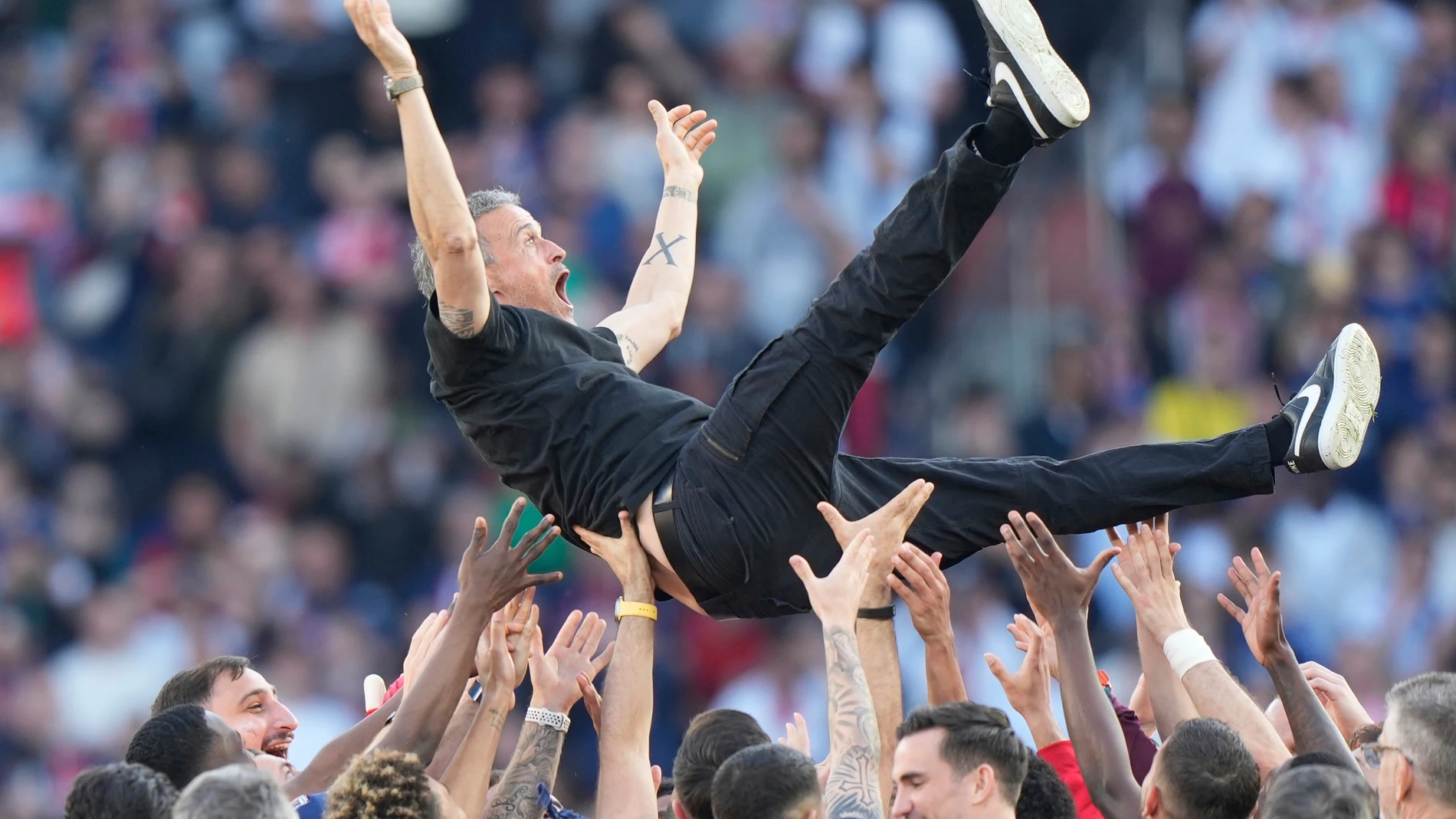 Paris Saint-Germain players throw PSG's head coach Luis Enrique in the air after they won the French League One soccer match between Paris Saint-Germain and Angers at Parc des Princes stadium in Paris, Saturday, April 5, 2025. (AP Photo/Michel Euler)
