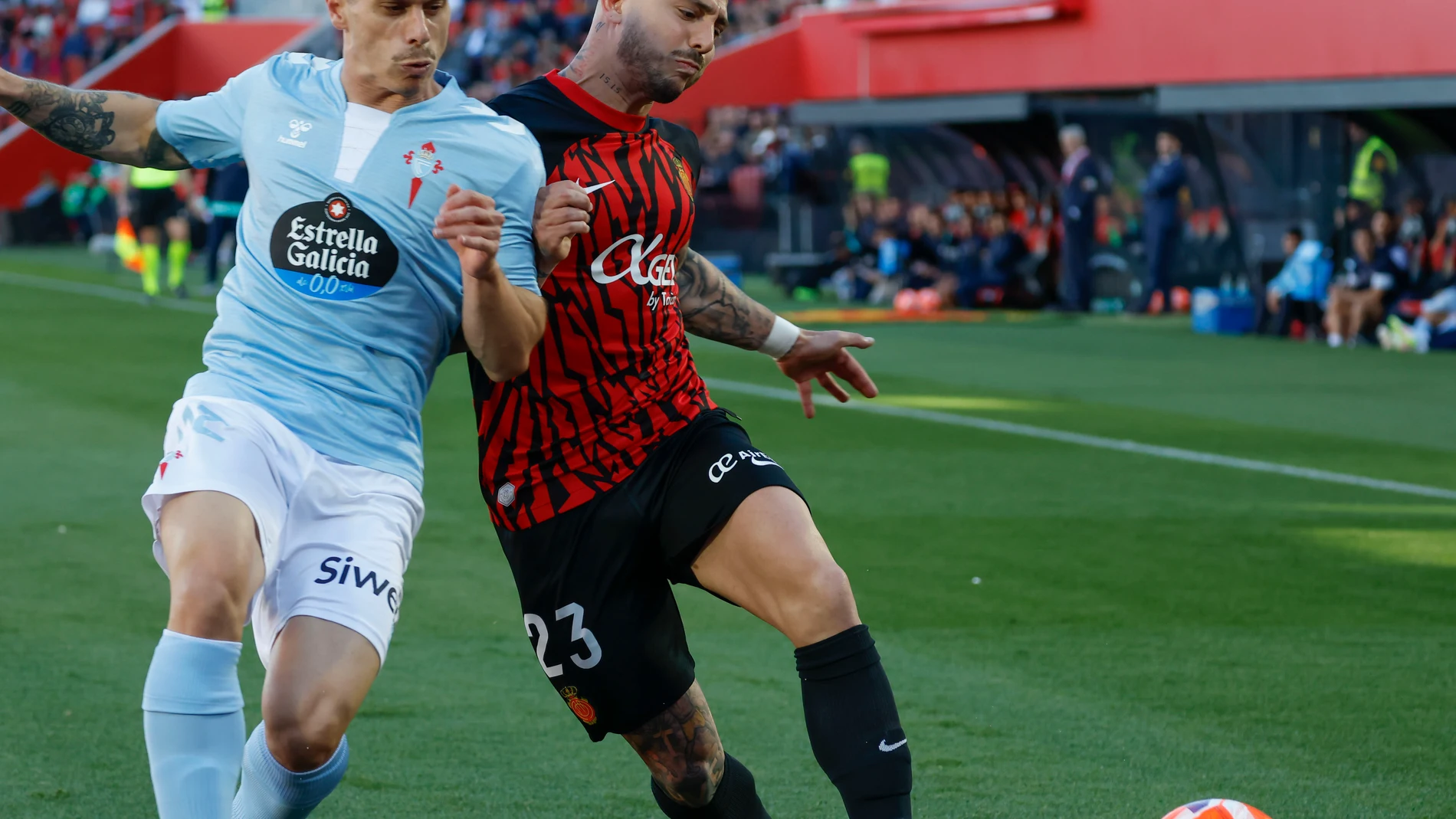 PALMA DE MALLORCA, 05/04/2025.- El defensa del Mallorca Pablo Maffeo (d) pelea un balón con el delantero del Celta Alfonso González durante el partido de LaLiga entre el Real Mallorca y el Celta, este sábado en el estadio de Son Moix, en Palma. EFE/CATI CLADERA