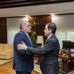 Mañueco saluda a Pedro Pascual, de Por Ávila, antes de su reunión