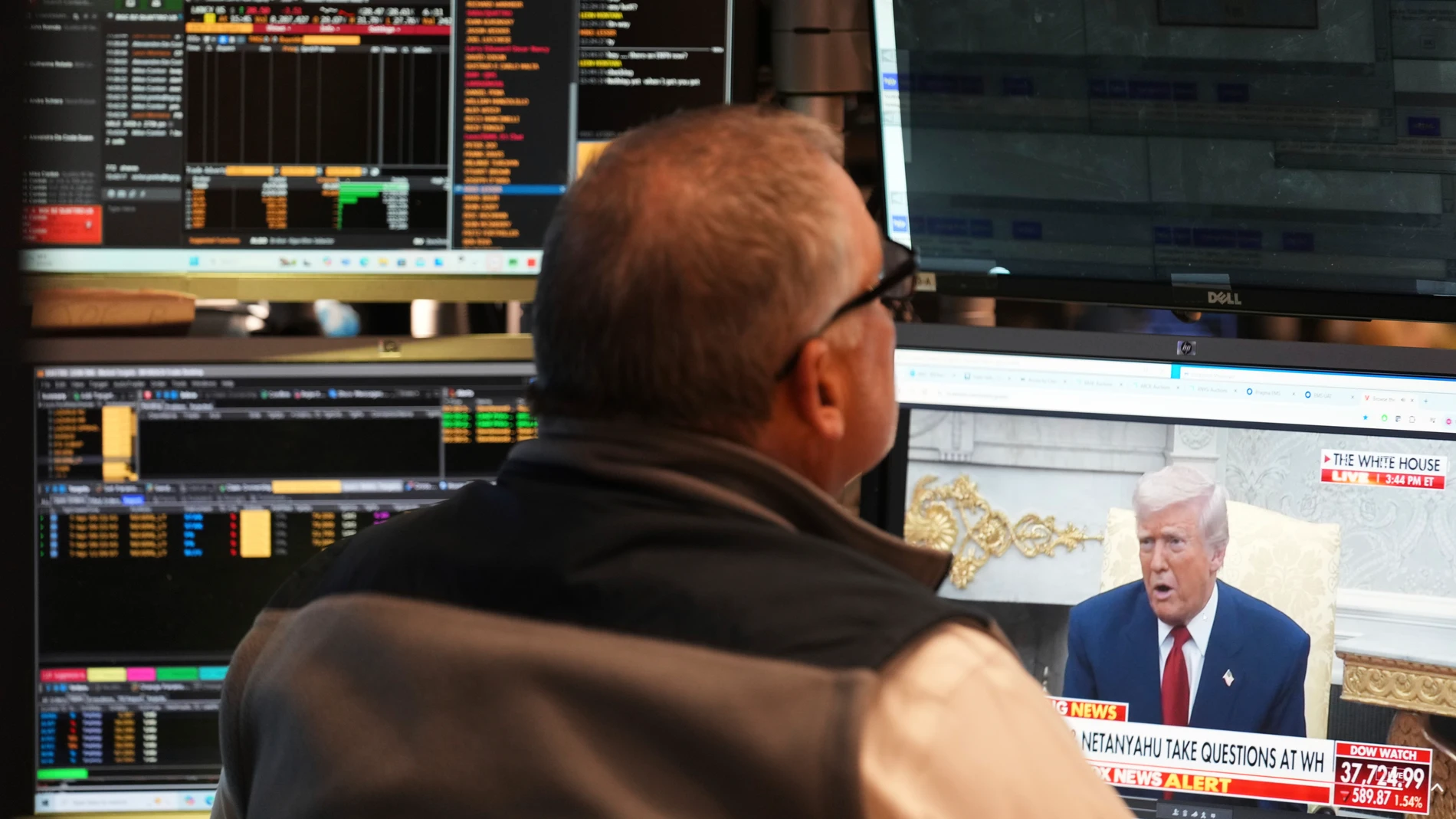 President Donald Trump is seen on the television as traders work on the floor at the New York Stock Exchange in New York, Monday, April 7, 2025. (AP Photo/Seth Wenig)