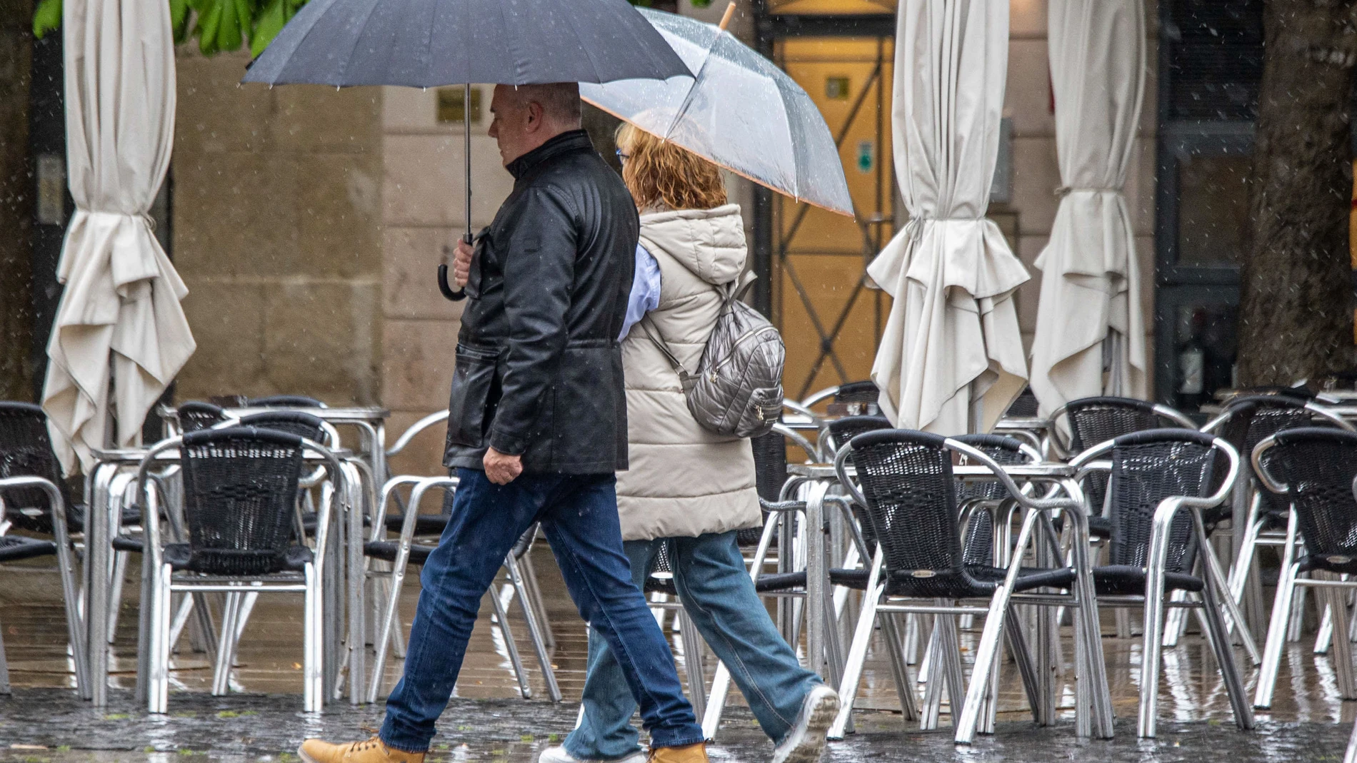 LOGROÑO 11/04/2025.- Unas personas protegidas con paraguas a su paso por Logroño este viernes. Mañana sábado la borrasca Olivier mantendrá en La Rioja el cielo cubierto, con chubascos moderados, preferentemente por la tarde, con probabilidad de tormentas ocasionales, que podrán ser fuertes e ir con granizo de forma local. Según los pronósticos de la Agencia Estatal de Meteorología (Aemet), las temperaturas no experimentarán cambios o lo harán en forma de leves aumentos en la comunidad riojana...