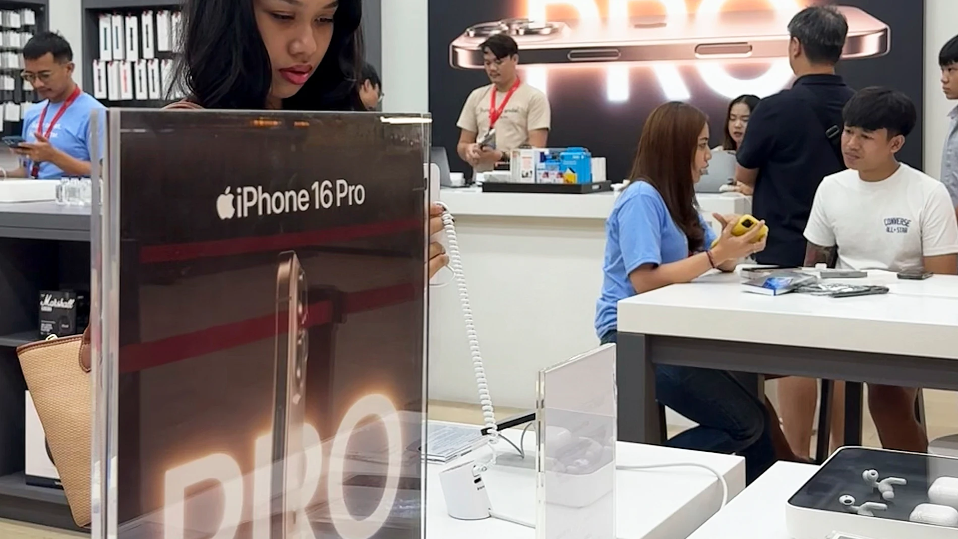 DENPASAR (Indonesia), 11/04/2025.- Customers inspect Apple iPhone 16s at a mall in Denpasar, Bali, Indonesia, 11 April 2025. The iPhone 16 Series officially went on sale in Indonesia on 11 April 2025, after an agreement was reached between the Indonesian Industry Ministry and Apple regarding investment plans in Indonesia. EFE/EPA/MADE NAGI