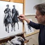 El pintor de batallas, Augusto Ferrer-Dalmau, retoca el boceto de dos guardias civiles a caballo.