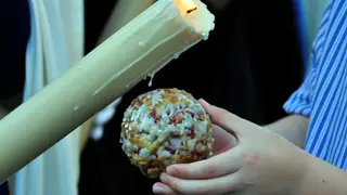 Imagen de un nazareno echando cera a un niño en Semana Santa Imagen de un nazareno echando cera a un niño en Semana Santa