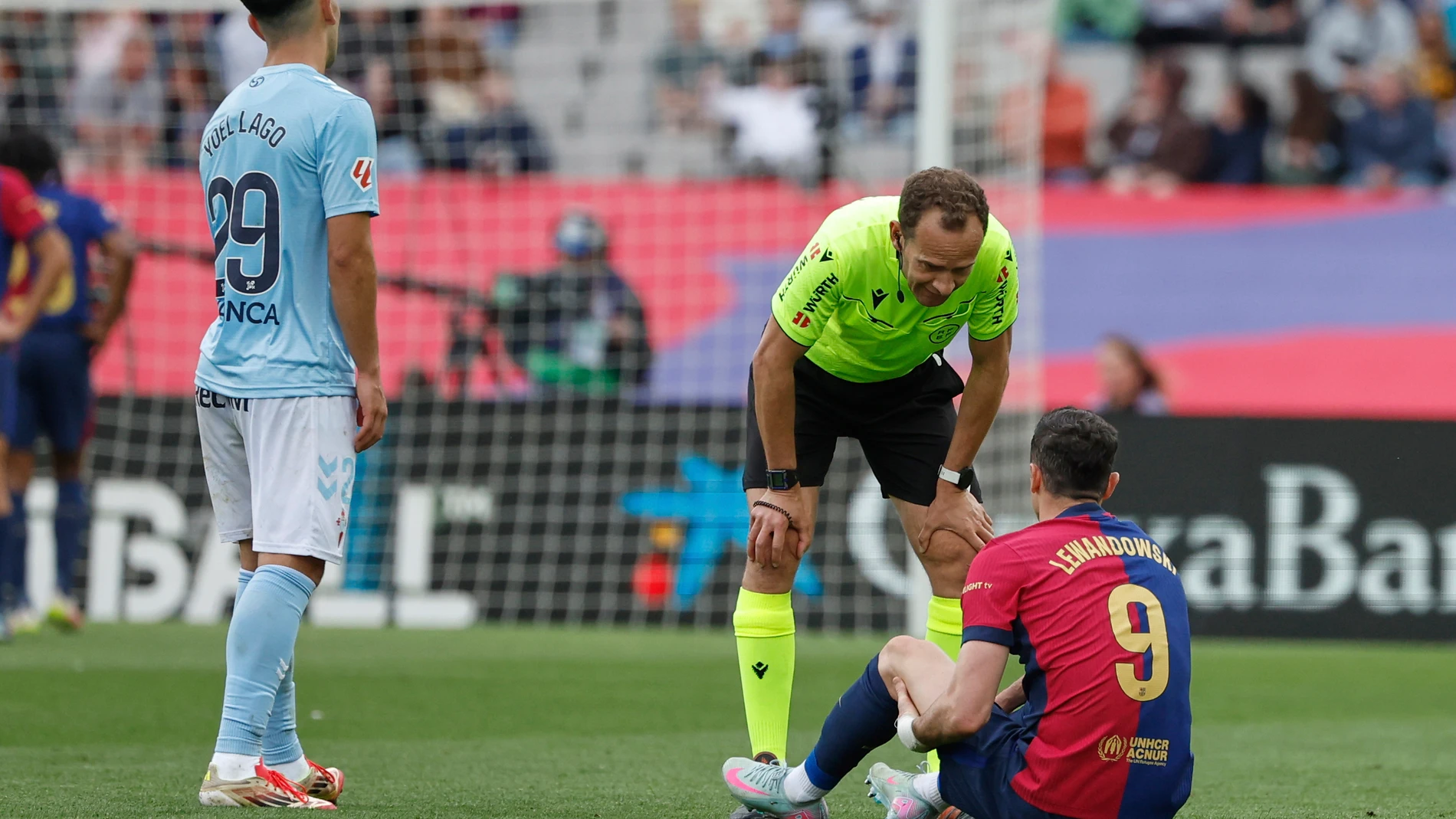 Referee Mario Melero Lopez talks with Barcelona's Robert Lewandowski during a Spanish La Liga soccer match between Barcelona and Celta de Vigo at the Lluis Companys Olympic stadium in Barcelona, Spain, Saturday, April 19, 2025. (AP Photo/Joan Monfort)