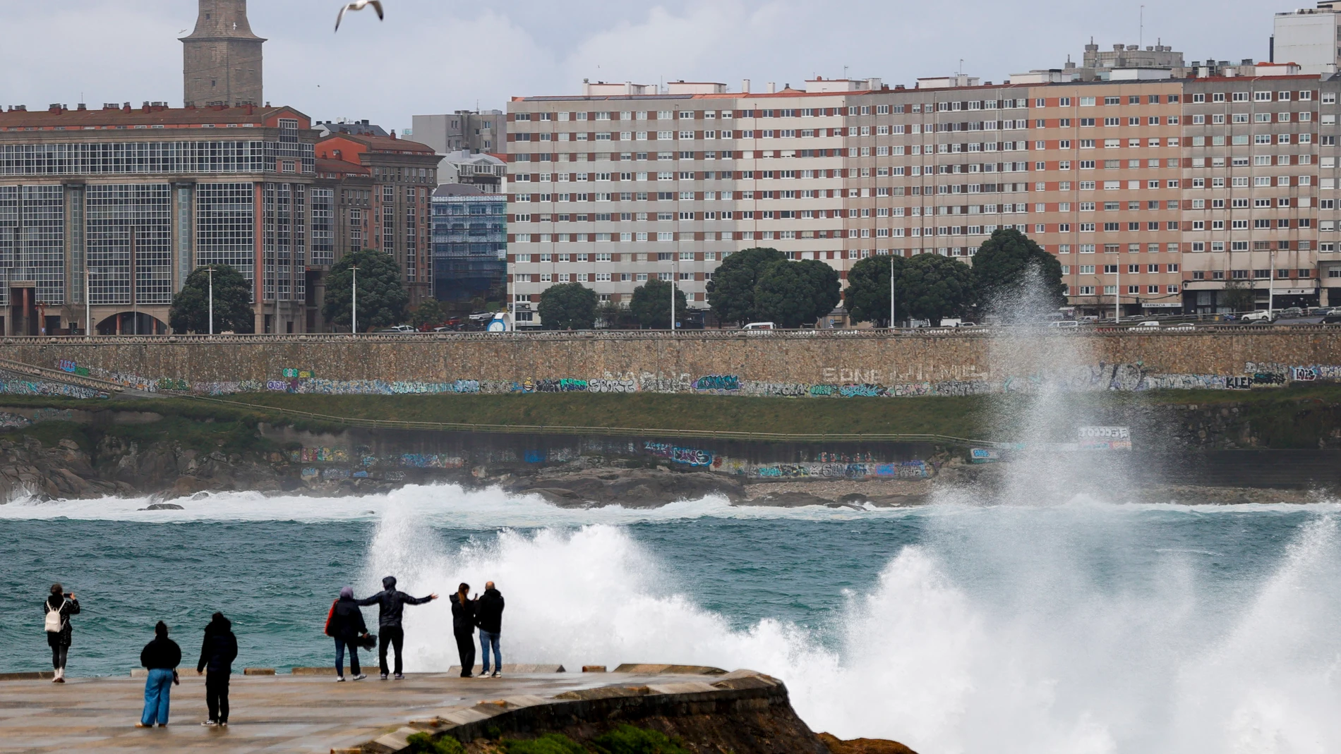 A CORUÑA, 19/04/25.- Varias personas se asoman al mar en el paseo marítimo de A Coruña en una jornada en la que a causa de los fenómenos meteorológicos adversos se mantiene activada la alerta naranja (riesgo importante) en el litoral atlántico, según informa la web de la Agencia Estatal de Meteorología. EFE/Cabalar
