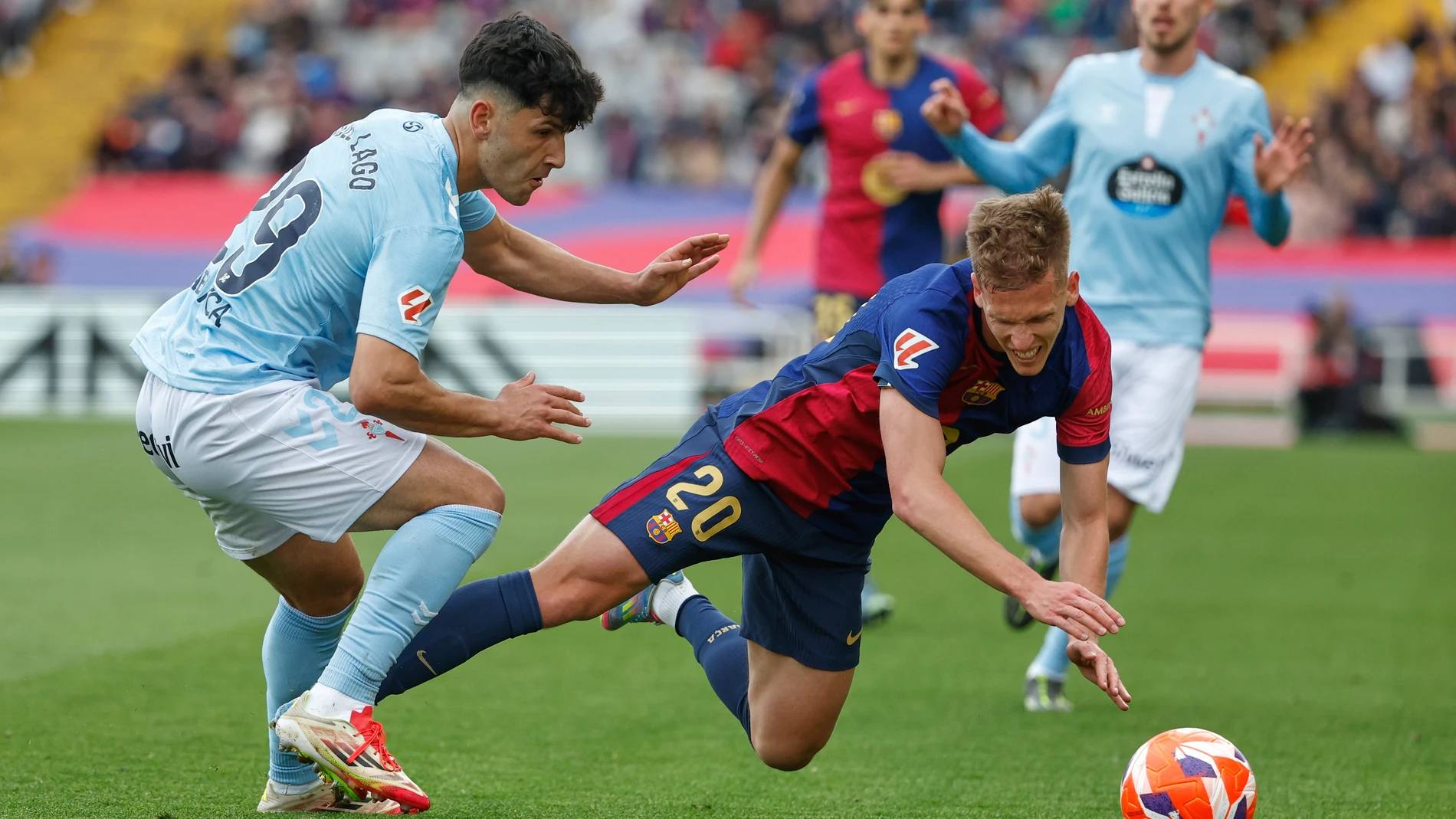 Celta's Yoel Lago, left, challenges for the ball with Barcelona's Dani Olmo during a Spanish La Liga soccer match between Barcelona and Celta de Vigo at the Lluis Companys Olympic stadium in Barcelona, Spain, Saturday, April 19, 2025. (AP Photo/Joan Monfort)