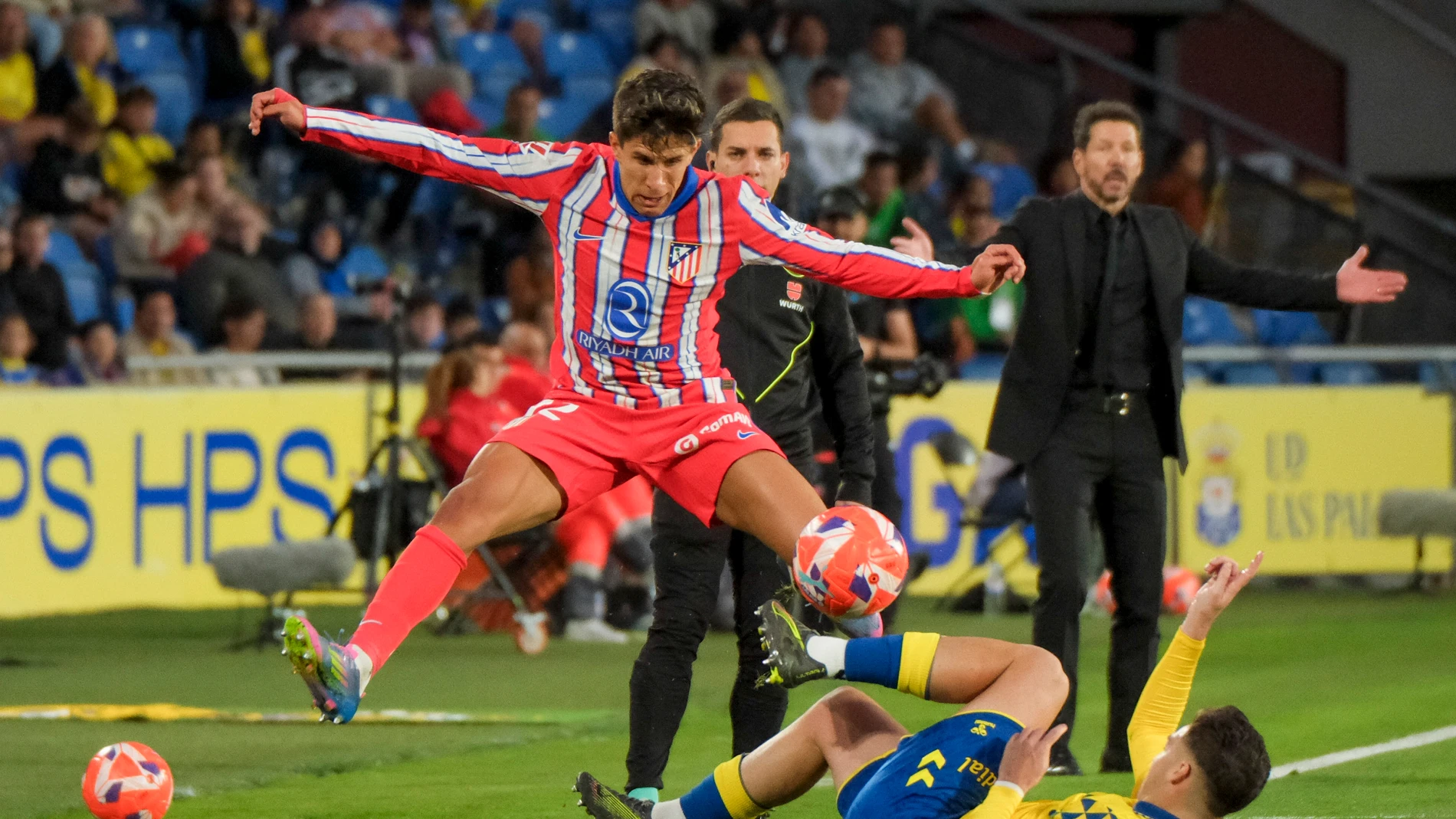 LAS PALMAS DE GRAN CANARIA, 19/04/2025.- El centrocampista del Atlético de Madrid Giuliano Simeone (i) lucha con Mika Mármol, de Las Palmas, durante el partido de la jornada 32 de LaLiga que UD Las Palmas y Atlético de Madrid disputan hoy sábado en el estadio de Gran Canaria. EFE/Ángel Medina G.