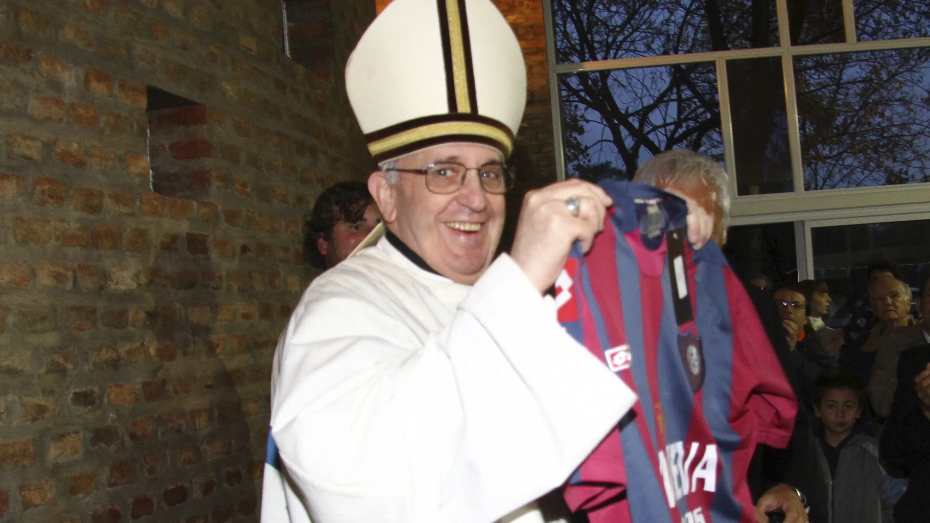 Fotografía sin fecha cedida por el Club argentino de fútbol San Lorenzo de Almagro hoy, jueves 14 de marzo de 2013, de Jorge Mario Bergoglio, quien fuera electo este miércoles como nuevo Papa de la Iglesia Católica en la capilla Sixtina del Vaticano, sosteniendo durante una misa la camiseta del equipo, del cual es socio y aficionado, en Buenos Aires, Argentina.