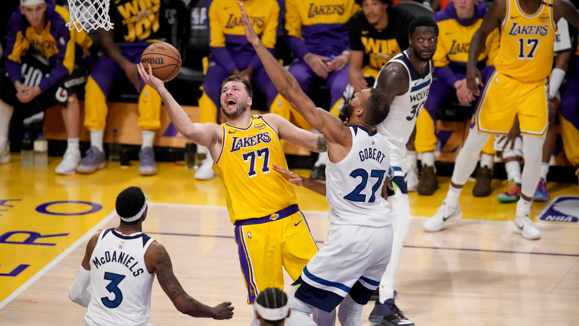 Los Angeles Lakers guard Luka Doncic (77) goes to the basket against Minnesota Timberwolves center Rudy Gobert (27) and forward Jaden McDaniels (3) during the second half of Game 2 of an NBA basketball first-round playoff in Los Angeles, Tuesday, April 22, 2025. (AP Photo/Eric Thayer)