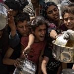  Palestinos desplazados hacen fila para recibir una ración de comida de un comedor social en Jabalia, al norte de la Franja de Gaza, 24 de abril de 2025. 