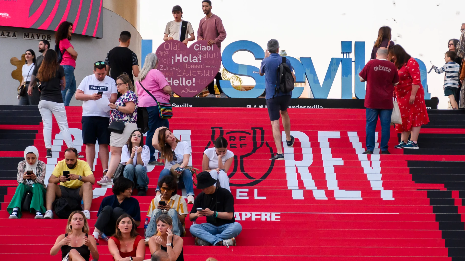 SEVILLA, 25/04/2025.- Varios grupos de personas este viernes, en la plaza de La Encarnación de Sevilla la víspera del encuentro de la final de la Copa del Rey que enfrenta al Real Madrid y al FC Barcelona. EFE/ Raúl Caro