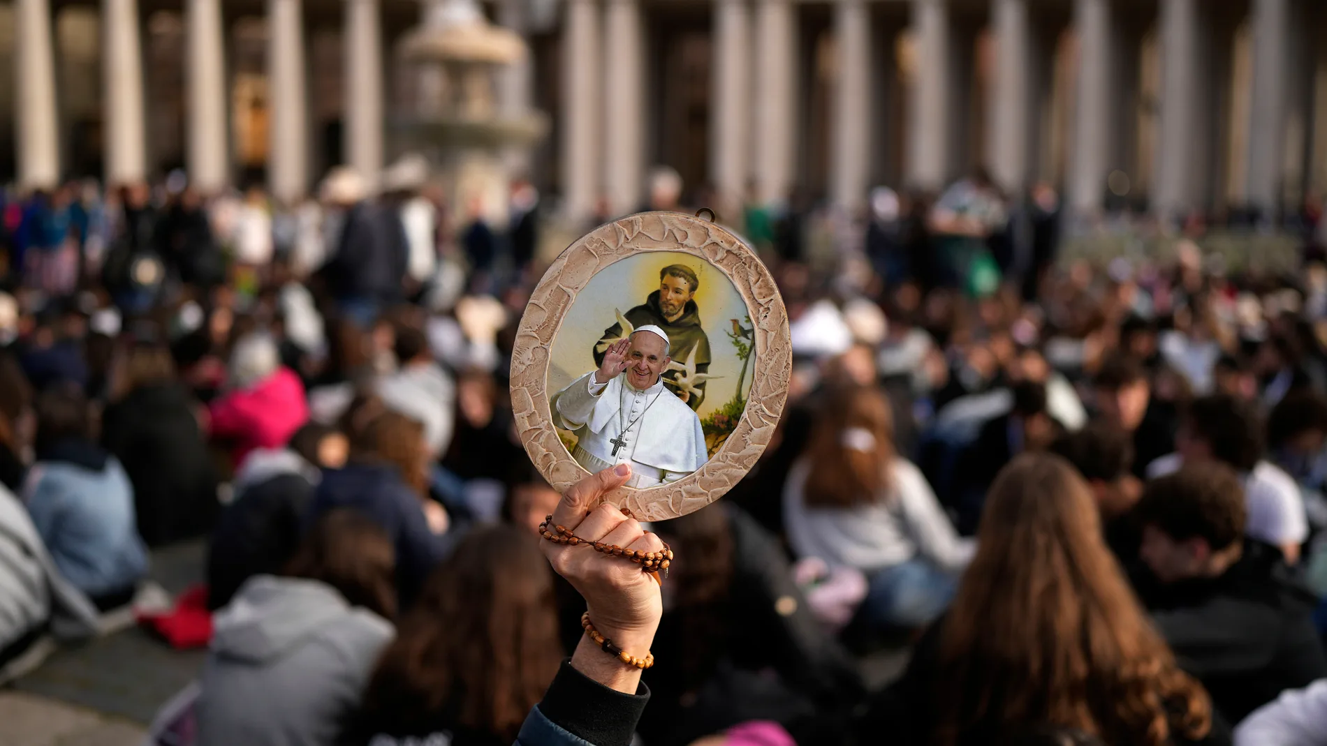 A person holds a depiction of Pope Francis as people wait for his funeral in St. Peter's Square at the Vatican, Saturday, April 26, 2025. (AP Photo/Andreea Alexandru)