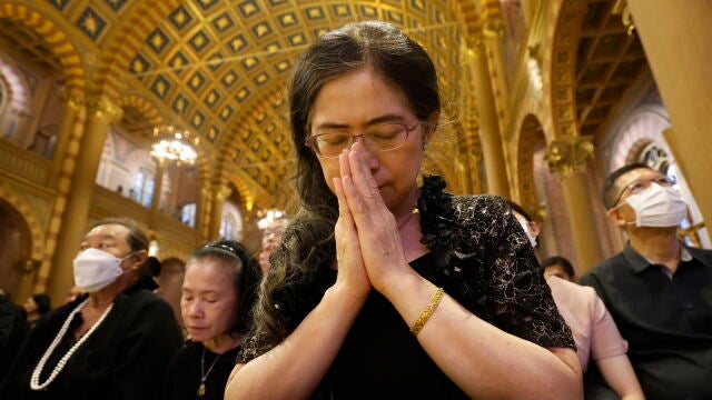 Fieles católicos rezan durante el funeral del Papa Francisco en Bangkok