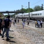 Passengers stand next to a stopped RENFE high-speed AVE train near Cordoba on April 28, 2025, during a massive power cut affecting the entire Iberian peninsula and the south of France. A "massive" power cut late on April 28, 2025 morning affected the whole of the Iberian peninsula and part of France, according to Portuguese electricity network operator REN.