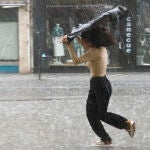 Una joven trata de resguardarse de la tormenta