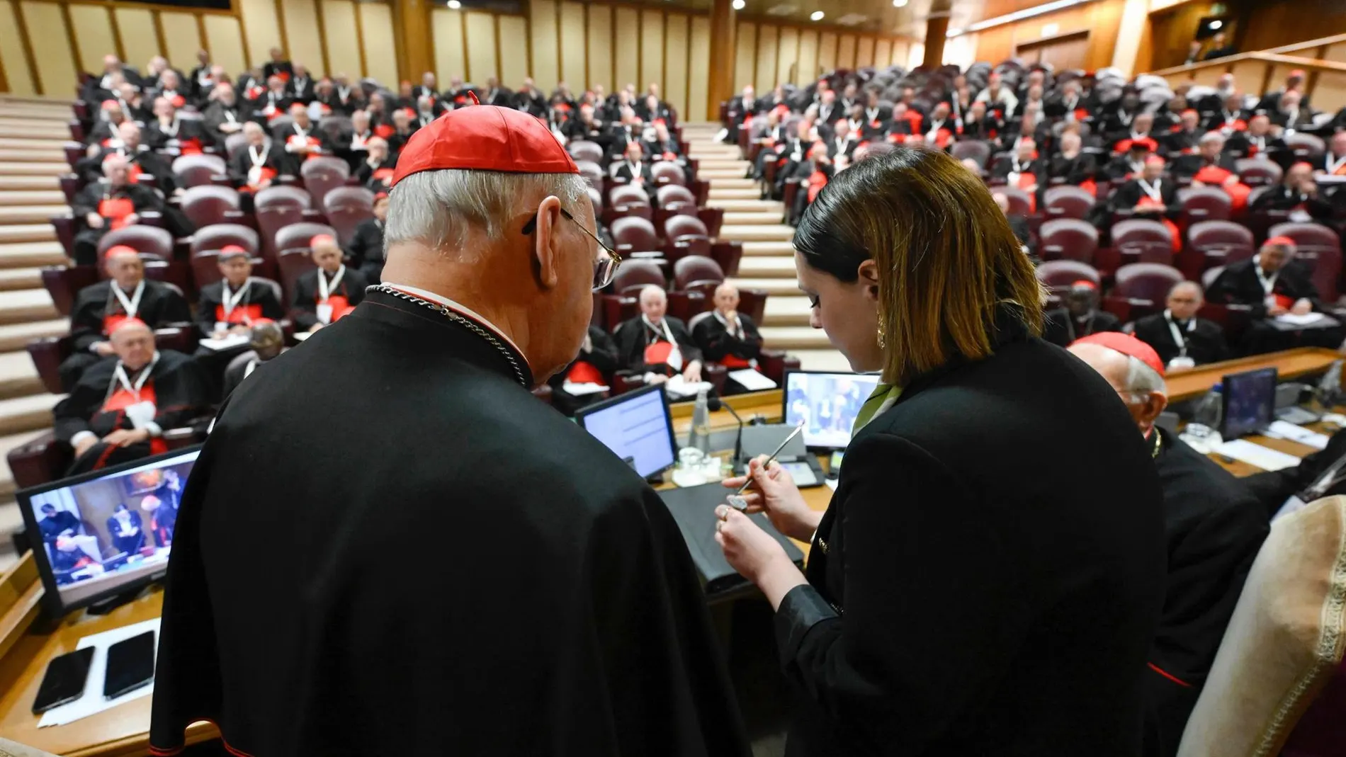 Una mujer anula el anillo del pescador durante la última reunión preparatoria de los cardenales