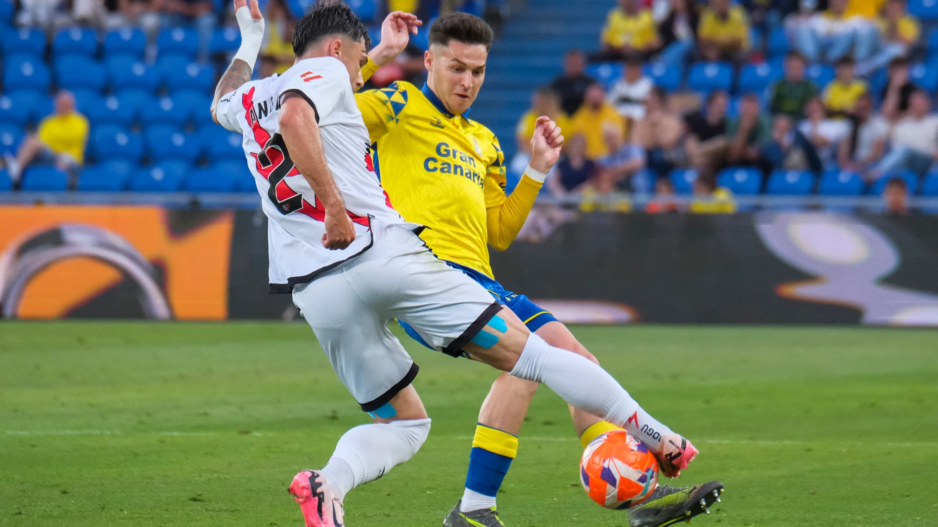 LAS PALMAS DE GRAN CANARIA, 09/05/2025.- El defensa del Rayo Vallecano Andrei Ratiu (i) pelea un balón con el defensa de la UD Las Palmas, Mika Marmol durante el encuentro correspondiente a la jornada 35 de Laliga EA Sports que disputan hoy viernes Las Palmas y Rayo en el Estadio de Gran Canaria. EFE / Angel Medina G.