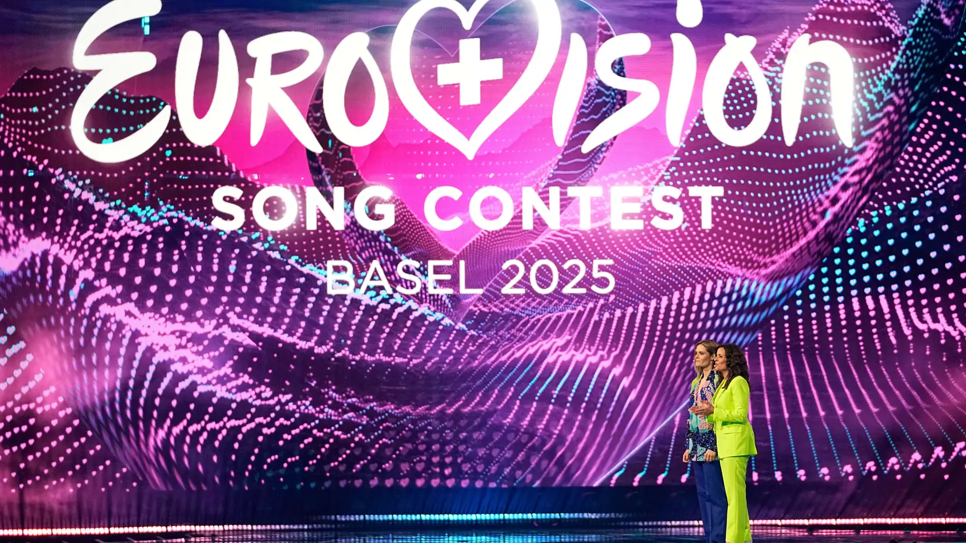 Hosts Hazel Brugger, left and Sandra Studer, on stage during the first semi-final of the 69th Eurovision Song Contest, in Basel, Switzerland, Tuesday, May 13, 2025. (AP Photo/Martin Meissner)