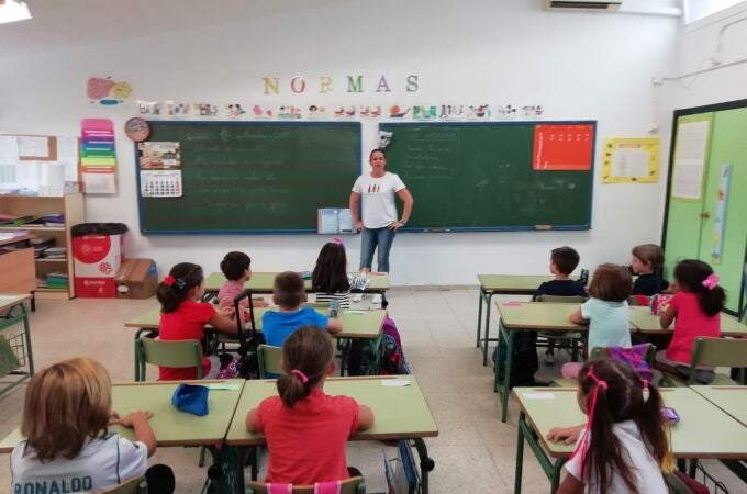 Una profesora da clases a alumnos de Primaria en un colegio público.