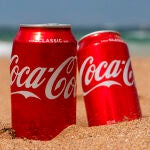 Dos latas de Coca-Cola en la playa