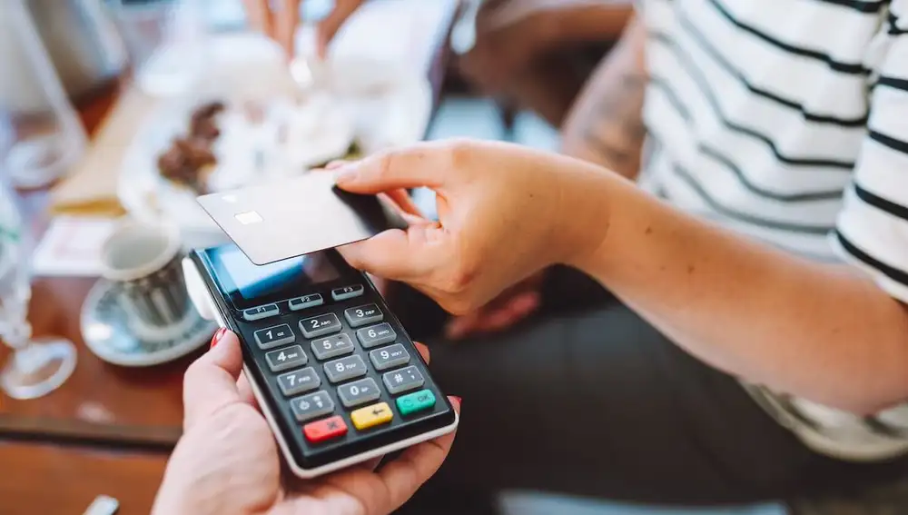 Una persona pagando con tarjeta de crédito en una cafetería