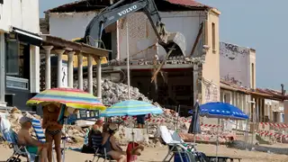 Bañistas en playa Babilonia en Guardamar del Segura, Alicante, entre cascotes Bañistas en playa Babilonia en Guardamar del Segura, Alicante, entre cascotes