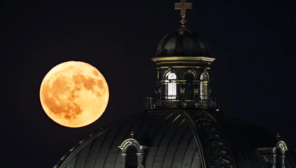 La luna de fresa esta noche junto al Parlamento en Berna, Suiza. Esta primera luna llena de junio coincide con un fenómeno astronómico poco común, el lunasticio, fenómeno por el cual el astro alcanza la inclinación más extrema dentro de su órbita, y no se volverá a repetir hasta el año 2043.
