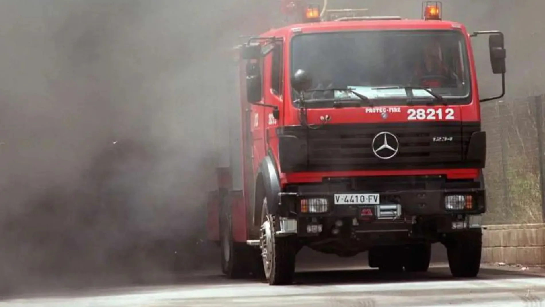 Imagen de archivo de un camión de bomberos entre una gran humareda