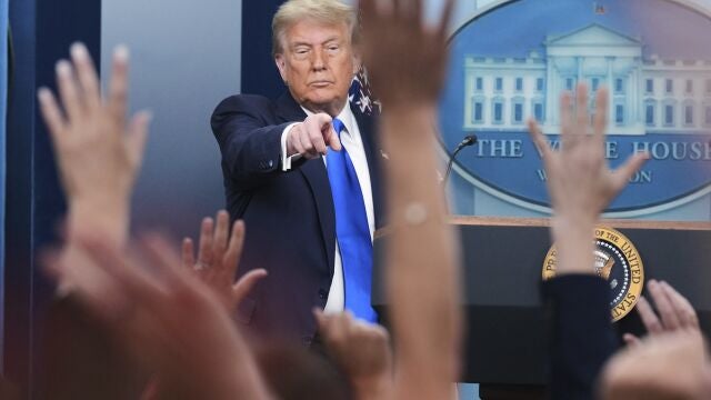 President Donald Trump points to a reporter to answer questions, in the briefing room of the White House in Washington.