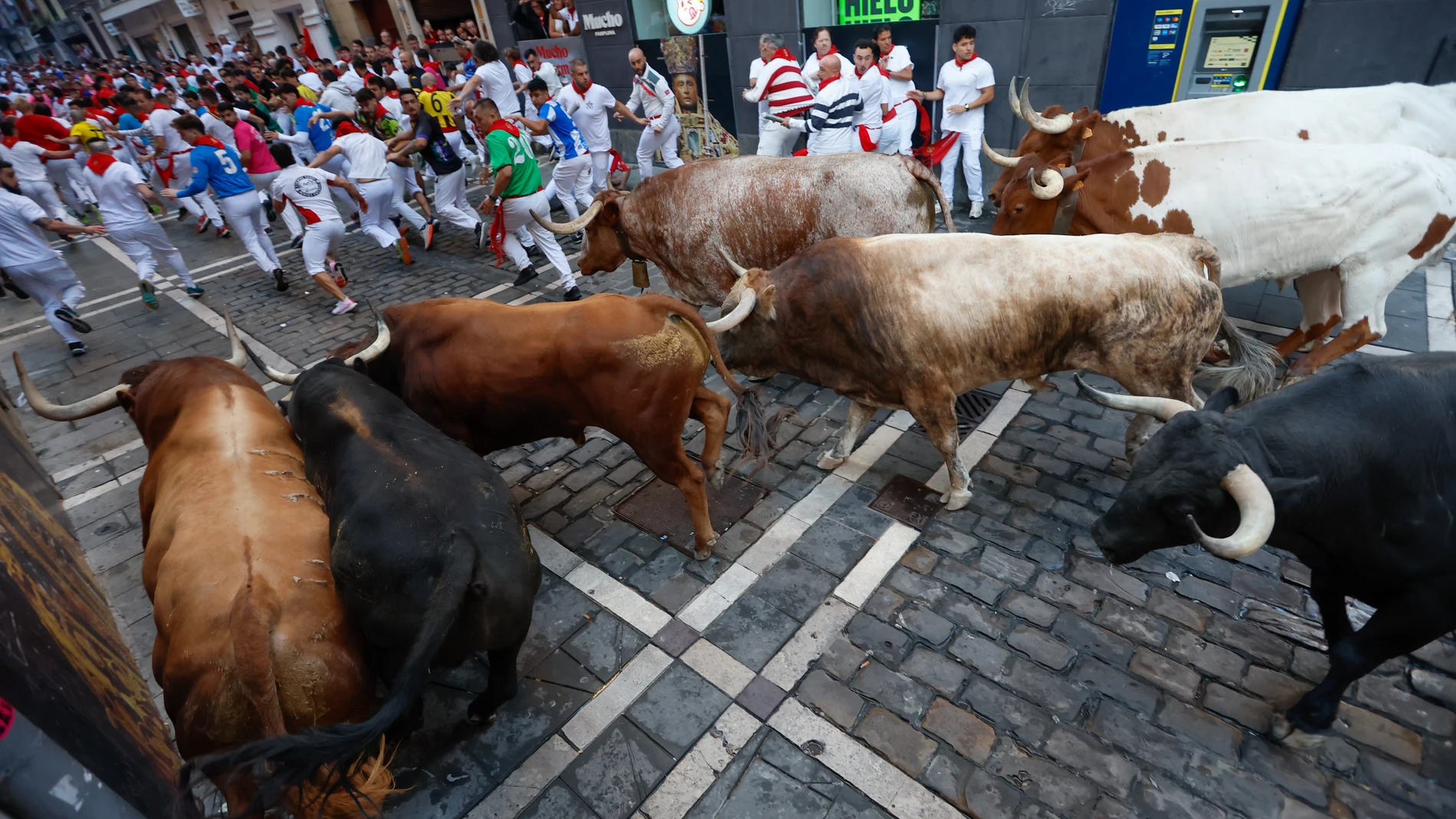 PAMPLONA, 10/07/2025.- Los mozos son perseguidos por los toros de la ganadería Victoriano del Río Cortés durante el cuarto encierro de los Sanfermines, este jueves, en Pamplona. EFE/Jesús Diges