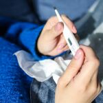 Una persona enferma utiliza un termómetro