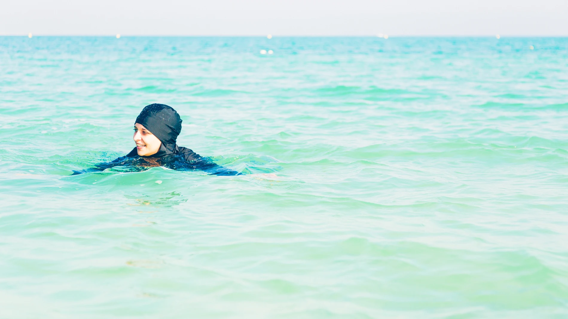Una mujer bañándose con un burkini