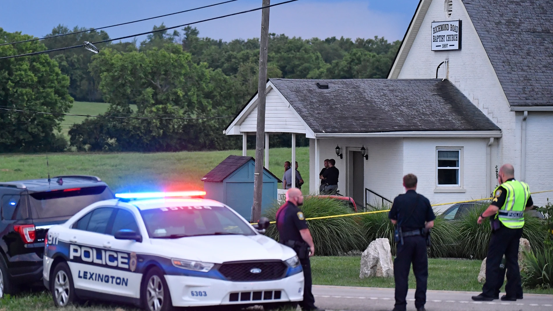 Police stand at the front of the Richmond Road Baptist Church as other officers maintain a perimeter following a shooting at the church in Lexington, Ky., Sunday, July 13, 2025. (AP Photo/Timothy D. Easley)
