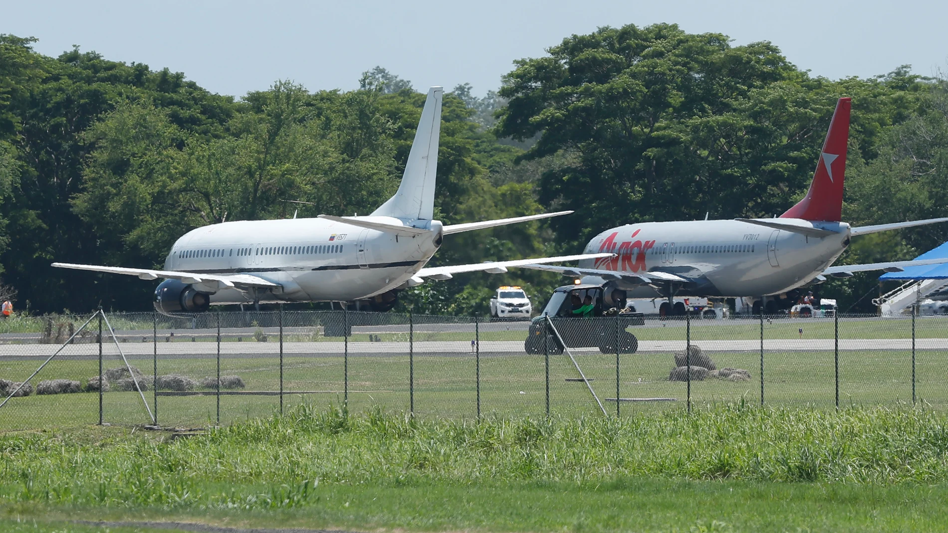 AME3734. SAN LUIS TALPA (EL SALVADOR), 18/07/2025.- Fotografía de aviones que transportan migrantes venezolanos detenidos en El Salvador con destino a Venezuela este viernes, en el aeropuerto Internacional San Oscar Romero en San Luis Talpa (El Salvador). EFE/ Rodrigo Sura