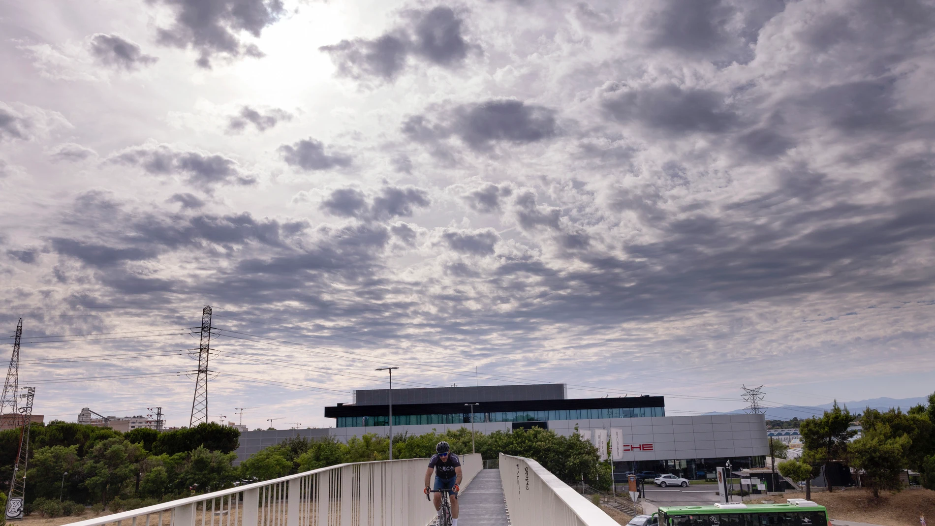 MADRID, 23/07/2025.- Una persona monta en bicicleta en Madrid este miércoles. España atraviesa estos días un inusual episodio fresco para esta época canicular, el periodo más cálido del verano, por la llegada de vientos del norte y noroeste que dejan temperaturas -diurnas como nocturnas- entre 5 y 10 grados por debajo de lo normal. EFE/Chema Moya