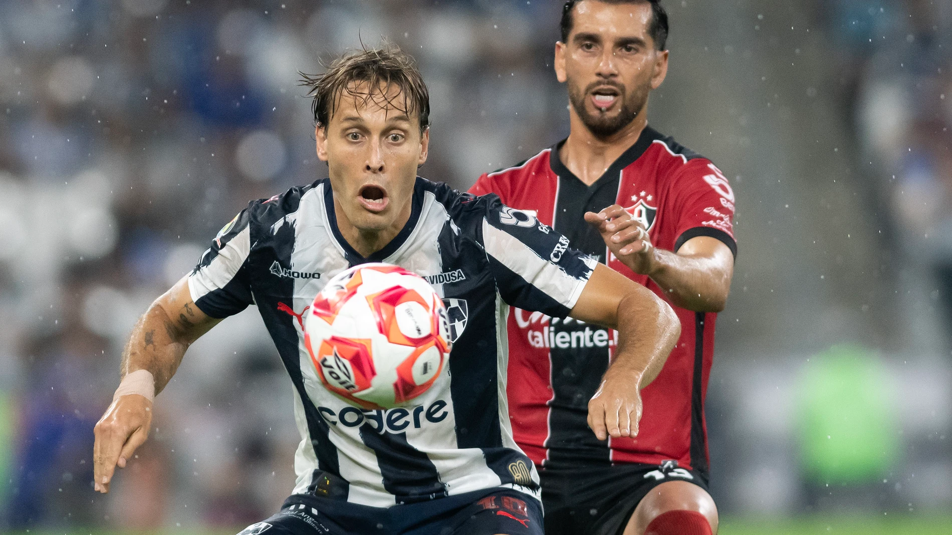 AME5591. MONTERREY (MÉXICO), 26/07/2025.- Sergio Canales (adelante) de Monterrey disputa el balón con Gaddi Aguirre (atrás) de Atlas este sábado, durante un partido de la Liga MX entre Monterrey y Atlas en el estadio BBVA en Monterrey (México). EFE/ Miguel Sierra