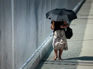 Viento muy fuerte en Castellón y bajada de las temperaturas para el último lunes de julio GRAFCVA8806. PAIPORTA (VALENCIA), 28/07/2025.- Una mujer se protege del sol con un paraguas durante este último lunes del mes de julio que estará marcado en la Comunitat Valenciana en lo meteorológico por las rachas de viento muy fuertes en el interior norte de la provincia Castellón y por la bajada de las temperaturas máximas. EFE/Biel Aliño