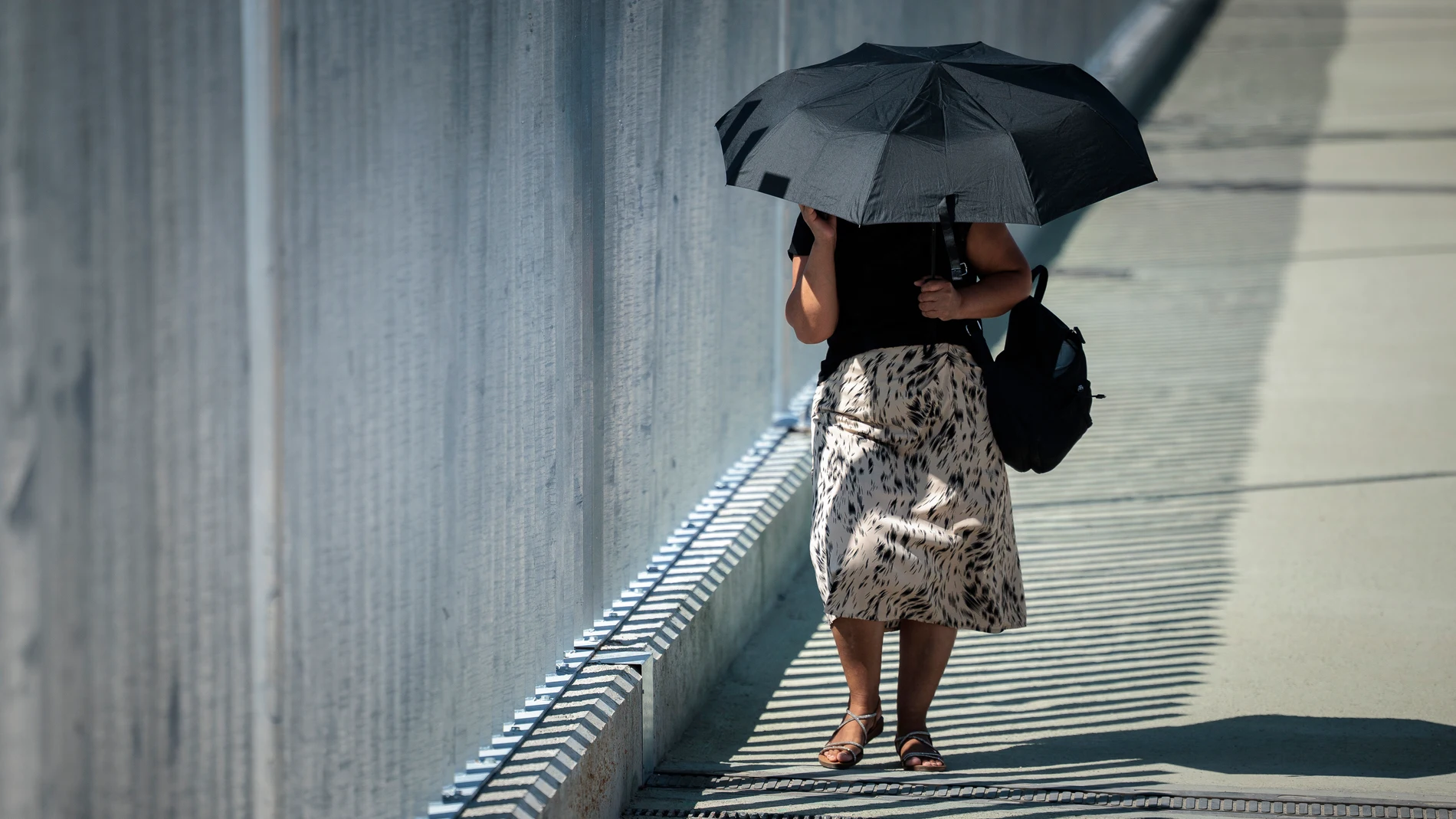 GRAFCVA8806. PAIPORTA (VALENCIA), 28/07/2025.- Una mujer se protege del sol con un paraguas durante este último lunes del mes de julio que estará marcado en la Comunitat Valenciana en lo meteorológico por las rachas de viento muy fuertes en el interior norte de la provincia Castellón y por la bajada de las temperaturas máximas. EFE/Biel Aliño