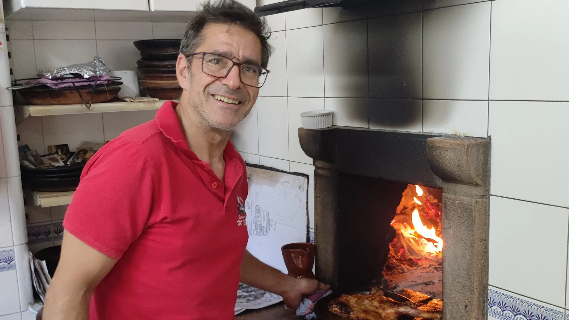 Marcos Benito, asador del Restaurante María Eugenia de Peñafiel, posa con un cuarto de lechazo junto al horno de leña