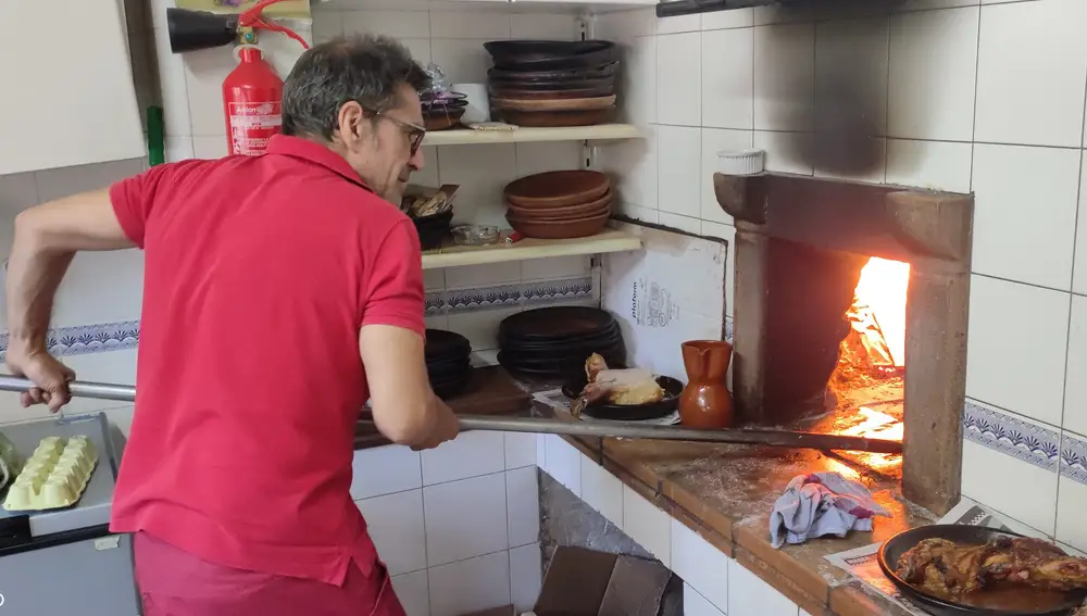 Marco Benito coloca los cuartos de lechazo con la pala de asar en el horno del Restaurante María Eugenia de Peñafiel