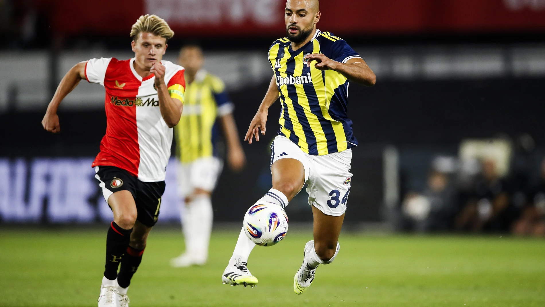 Rotterdam (Netherlands), 06/08/2025.- Sem Steijn of Feyenoord (L) in action against Sofyan Amrabat of Fenerbahce SK during the UEFA Champions League third qualifying round, 1st leg soccer match between Feyenoord Rotterdam and Fenerbahce SK, in Rotterdam, the Netherlands, 06 August 2025. (Liga de Campeones, Países Bajos; Holanda) EFE/EPA/BART STOUTJESDIJK