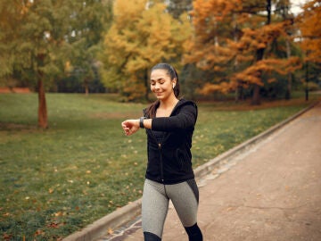 Persona caminando al aire libre usando smartwatch para contar pasos diarios